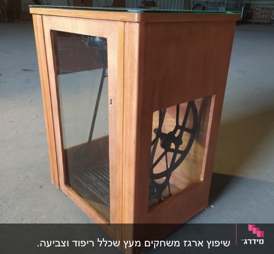 ארון עץ עם דלת זכוכית וגלגל מתכת בפנים